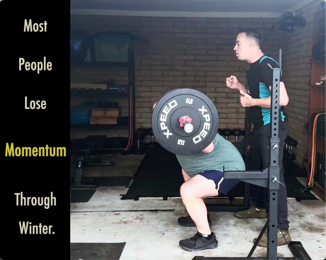 Anonymous athlete performing a barbell squat during structured strength training at guzzFIT in Traralgon